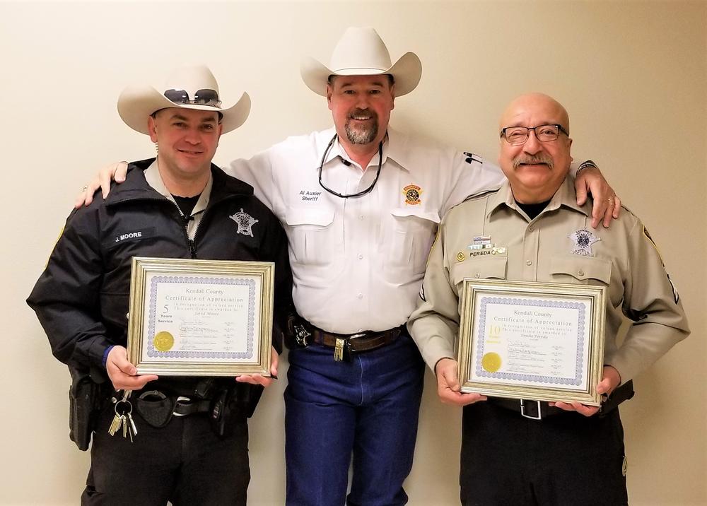 Sheriff recognizing two officers with certificates 